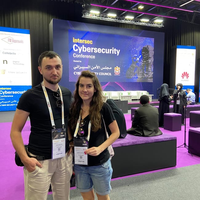 Uczestnicy na intersec cybersecurity conference w dubaju pozują przed sceną konferencyjną.
