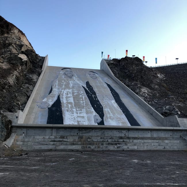 Hatta dam w zea z muralem na betonowym zboczu i skalnymi zboczami po bokach