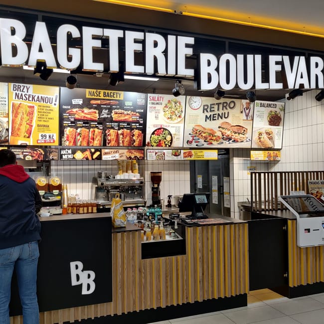 Wnętrze lokalu bagueterie boulevard w pradze z ladą i menu nad barem