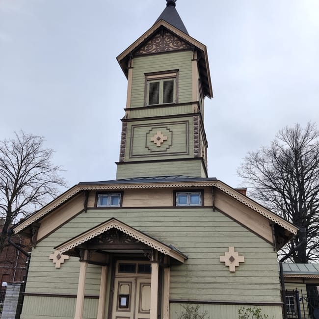 Tallinn church building with a green wooden facade and decorative cross details