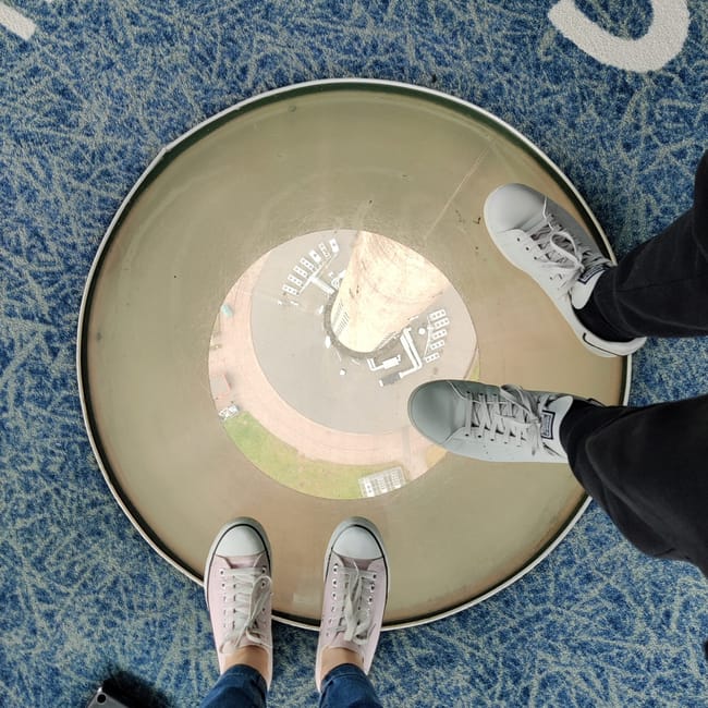 Tallinn article photo showing shoes standing on a circular viewing platform with a city map beneath