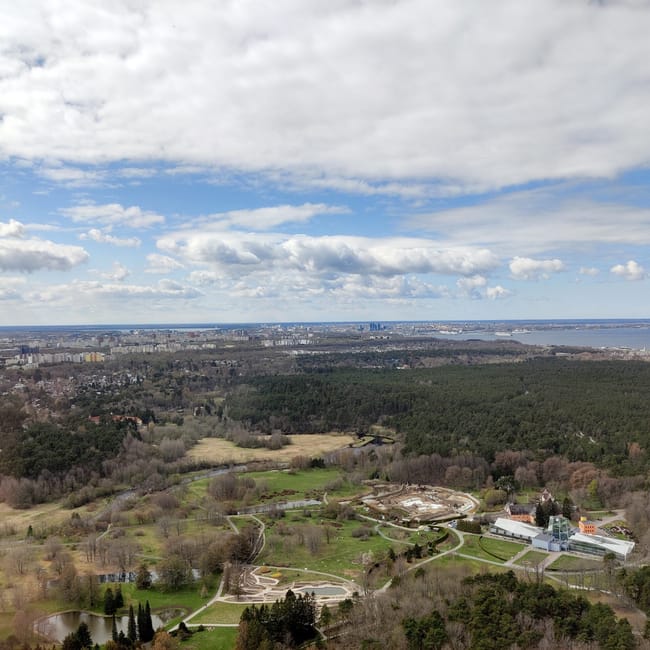 Aerial view over tallinn, estonia showing green parkland and city skyline under cloudy skies