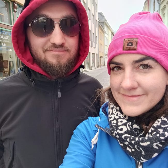 Couple taking a selfie on a tallinn street in estonia, wearing winter hats and jackets