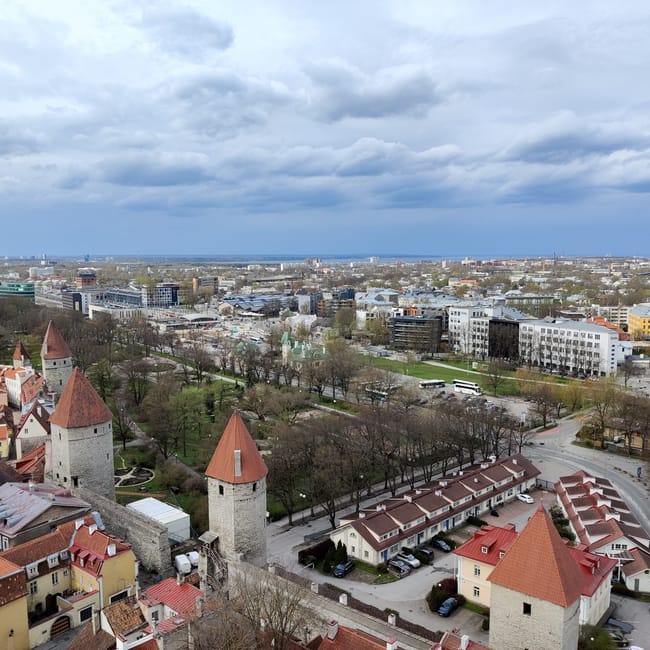 Tallinn, estonia cityscape with red-roofed towers and modern buildings under cloudy skies