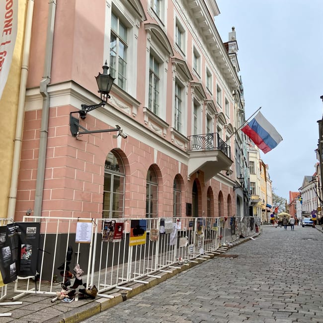 Tallinn street scene in estonia with an estonian flag outside historic buildings and a sidewalk display boards