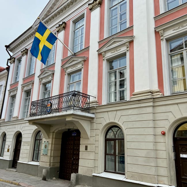 Tallinn estonia building facade with swedish flag on a balcony and arched entrances