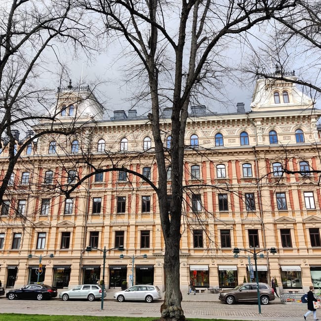 Esplanadi w helsinkach z zabytkową kamienicą i bezlistnymi drzewami