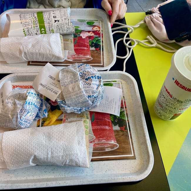 Tace z burgerami i napojem w restauracji hesburger w wilnie