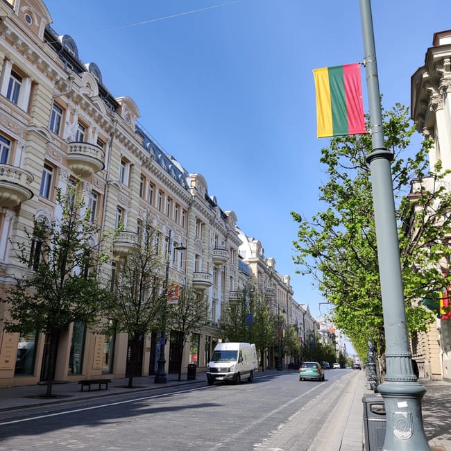 Ulica w starym mieście w wilnie z secesyjnymi kamienicami i litewską flagą na latarni