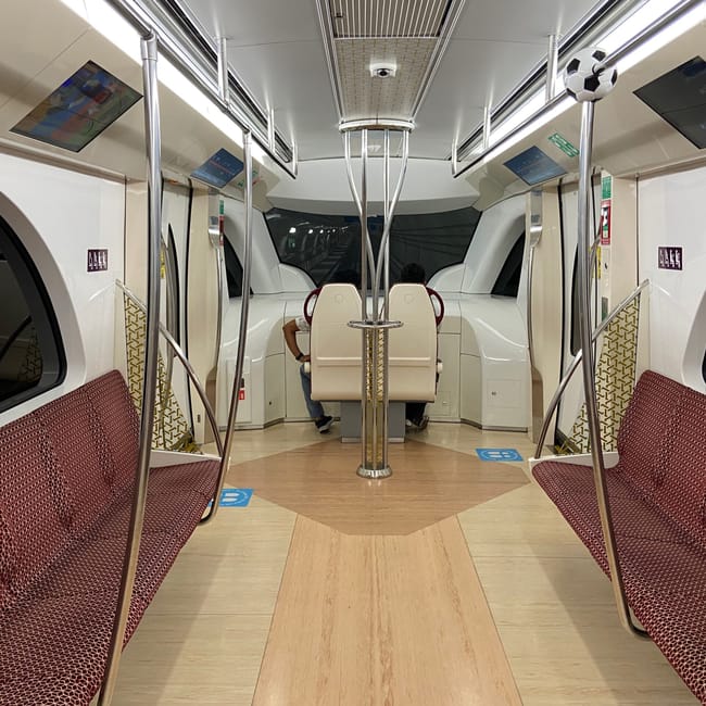 Wnętrze metra w doha z nowoczesnymi siedzeniami i pasażerami na końcu wagonu