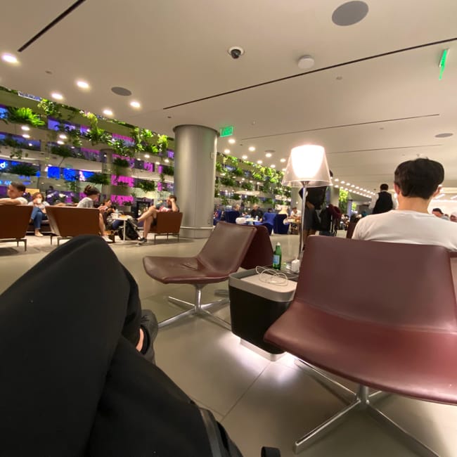 Sala biznesowa doha business lounge na lotnisku w dosze z pasażerami i nowoczesnymi fotelami