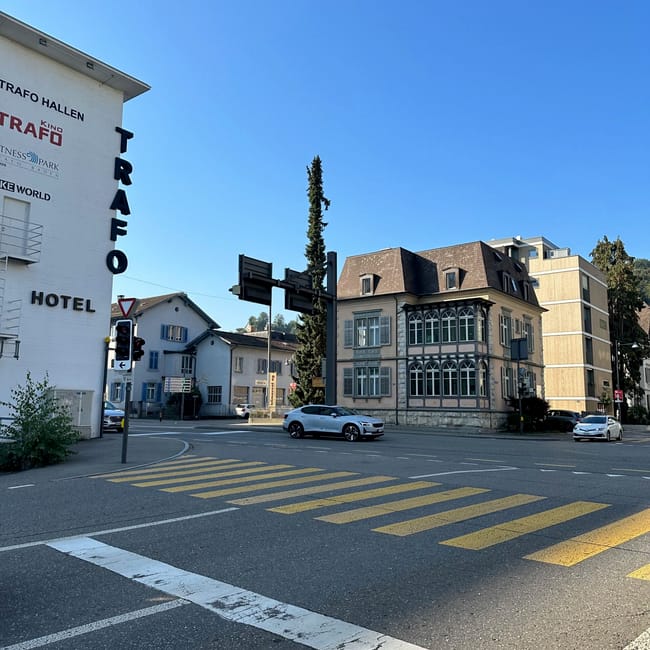 Ulica w zurychu z budynkiem trafo hotel i skrzyżowaniem pod błękitnym niebem