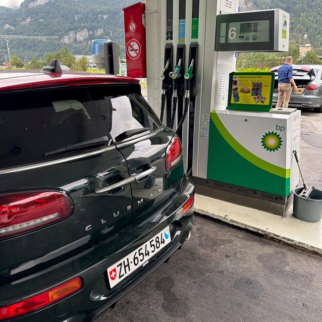 Tankowanie auta na stacji bp w interlaken, z górskim krajobrazem w tle.