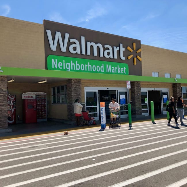 Wejście do walmart neighborhood market w kalifornii z klientami i wózkami sklepowymi