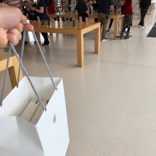 Sklep apple park w mountain view, z klientami przy stołach i torbą apple na pierwszym planie