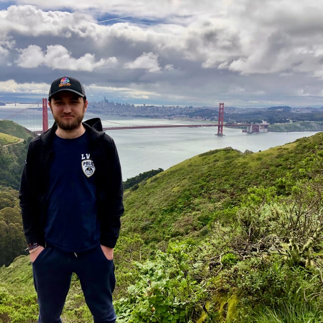 Mężczyzna na wzgórzu z widokiem na most golden gate bridge w san francisco.