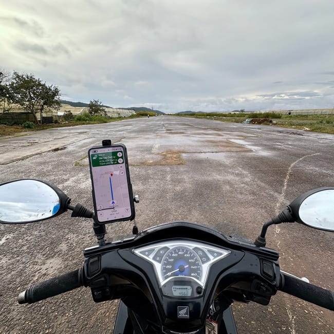 Motocykl na pustym pasie przy drodze w da lat, wietnam, z nawigacją na ekranie telefonu.