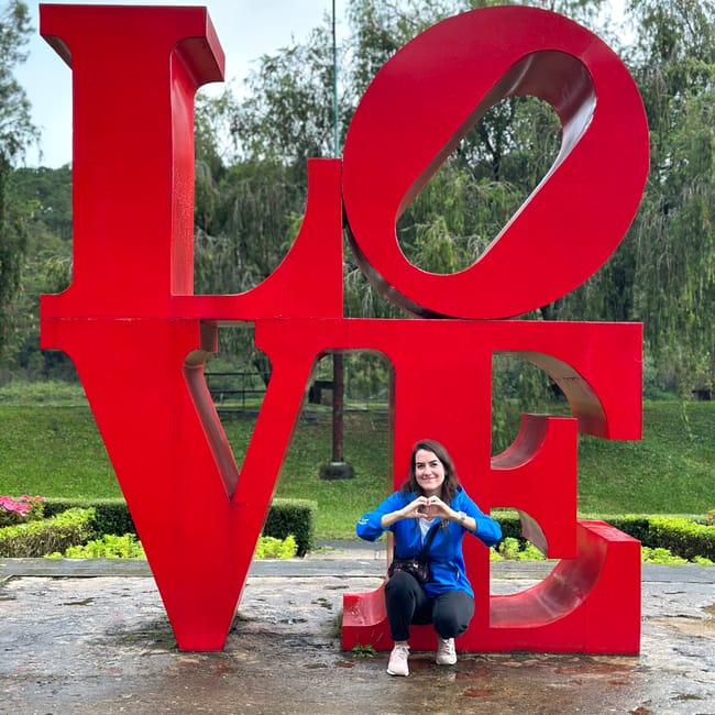 Da lat love valley: czerwony napis love z siedzącą kobietą robiącą serce dłońmi.