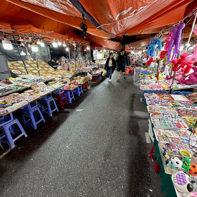 Wieczorny targ son tra night market w da nang z kolorowymi stoiskami i spacerującymi ludźmi