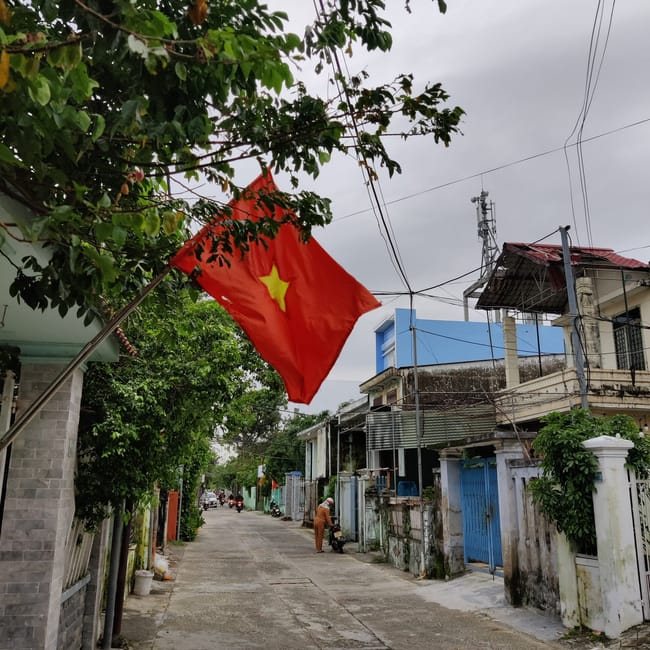 Ulica w da nang z powiewającą flagą wietnamu i niską zabudową.