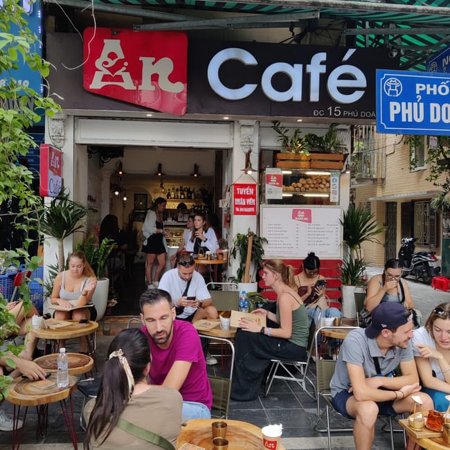 Kawiarnia an cafe przy ulicy phố phủ doãn w hanoi z siedzącymi gośćmi na zewnątrz