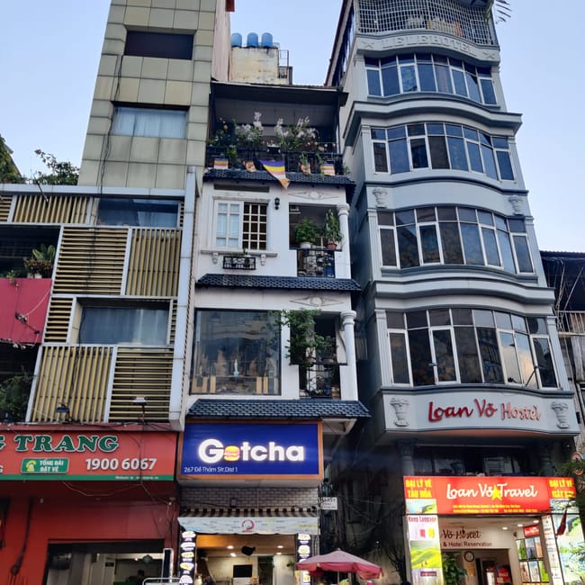 Ho chi minh, vietnam: wąska uliczka z wysokimi budynkami, lokalami i wejściem do loana vo hotel.