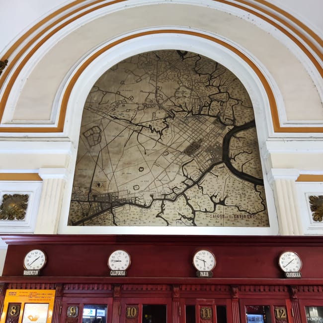 Wnętrze ho chi minh post office z mapą sajgonu i zegarami na ścianie