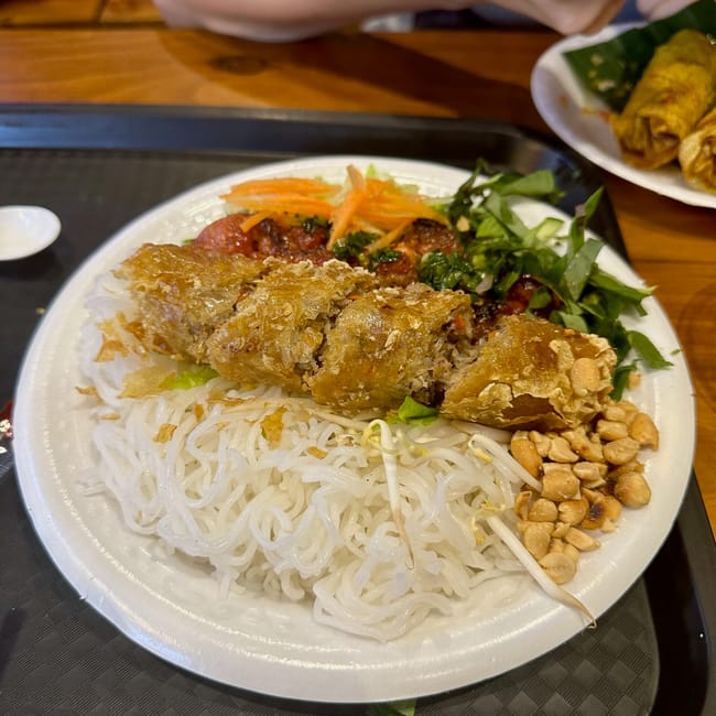 Ben nghe street food w ho chi minh z talerzem wietnamskiego jedzenia z makaronem i chrupiącą rolką