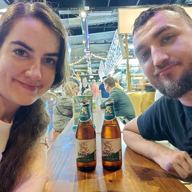 Selfie przy stole w ben nghe street food w ho chi minh z dwiema butelkami bia saigon.