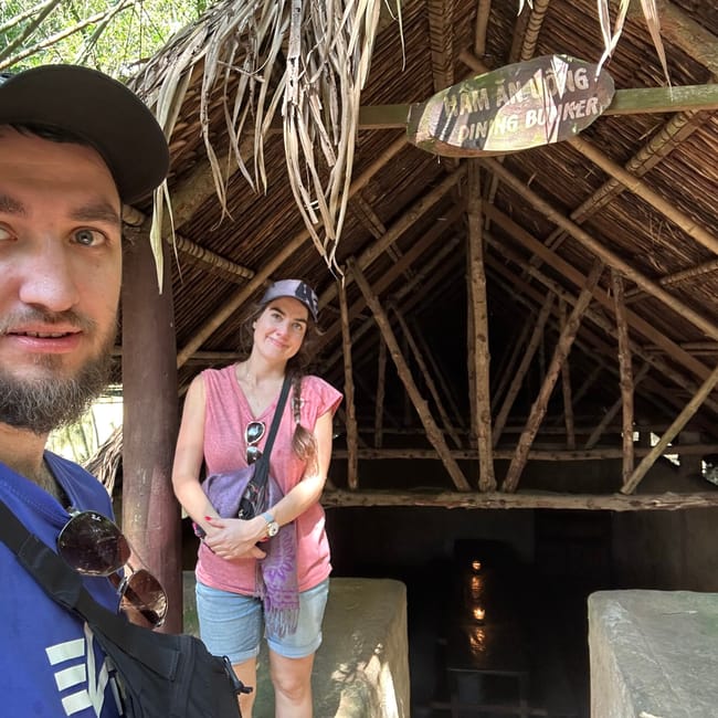Para wejścia do tunelu cu chi w ho chi minh z wiszącą tablicą i dwojgiem turystów.