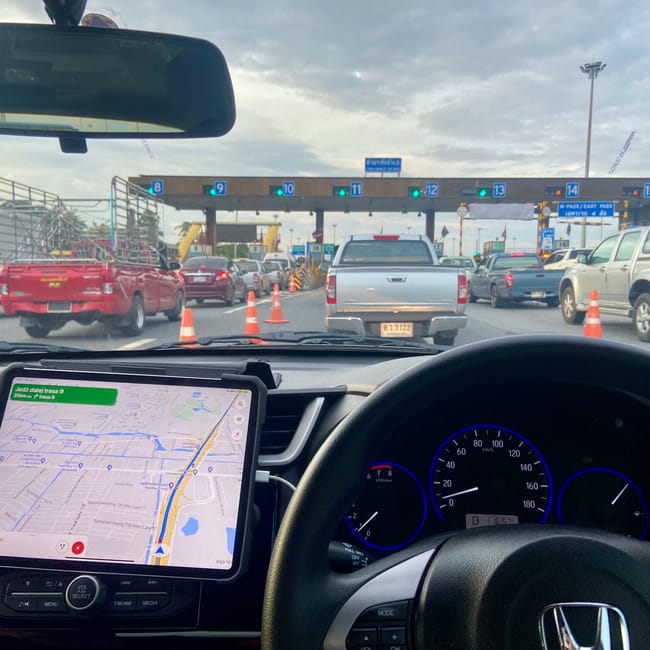 Driving in bangkok, thailand highway toll gate with traffic and dashboard navigation visible in the foreground