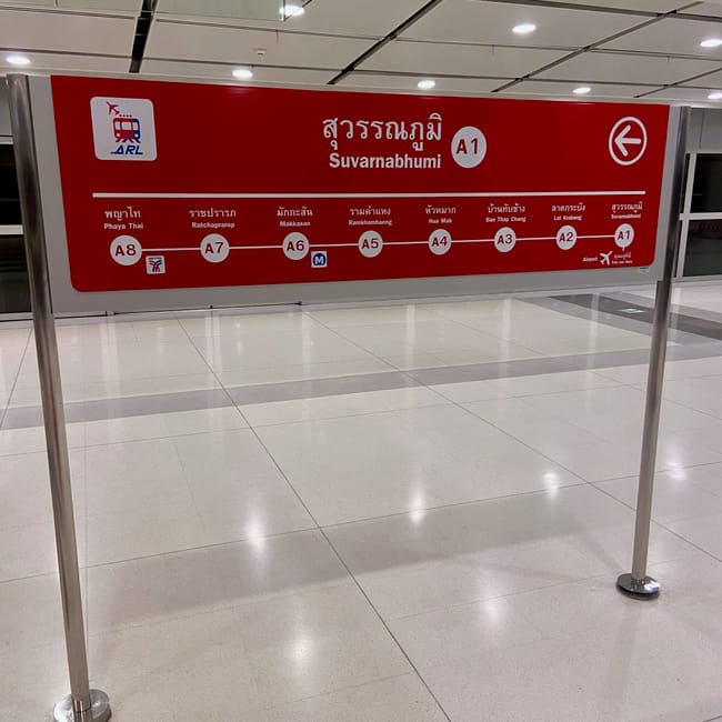 Czerwony znak kierunku na lotnisku suvarnabhumi w bangkoku, tajlandia.