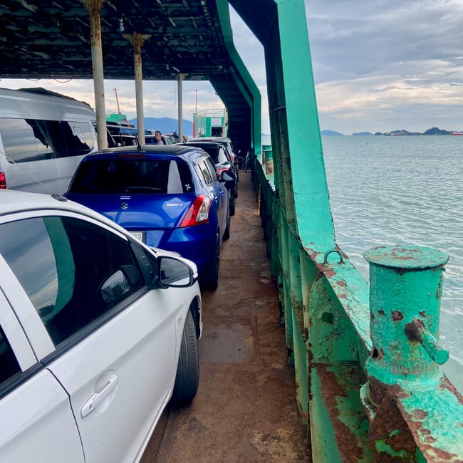 Prom na koh chang z samochodami i widokiem na morze.