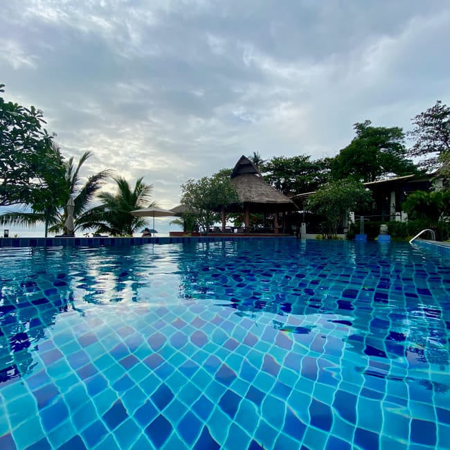 Basen hotelowy na koh chang w tajlandii z widokiem na palmy i morze