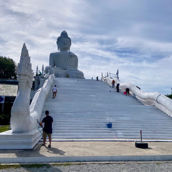 Phuket big buddha w tajlandii z szerokimi schodami i białą statuetką buddy na tle nieba