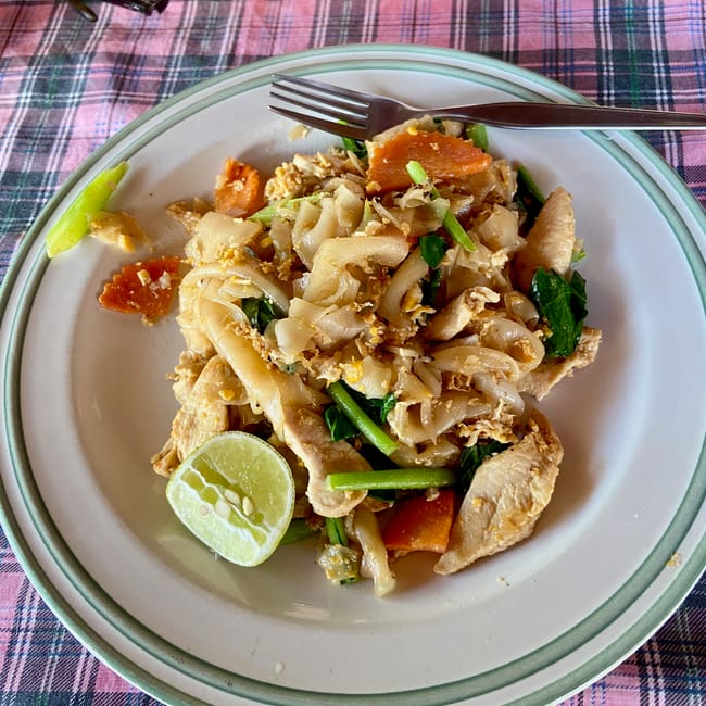Pad thai z kurczakiem i limonką na talerzu w phuket, tajlandia