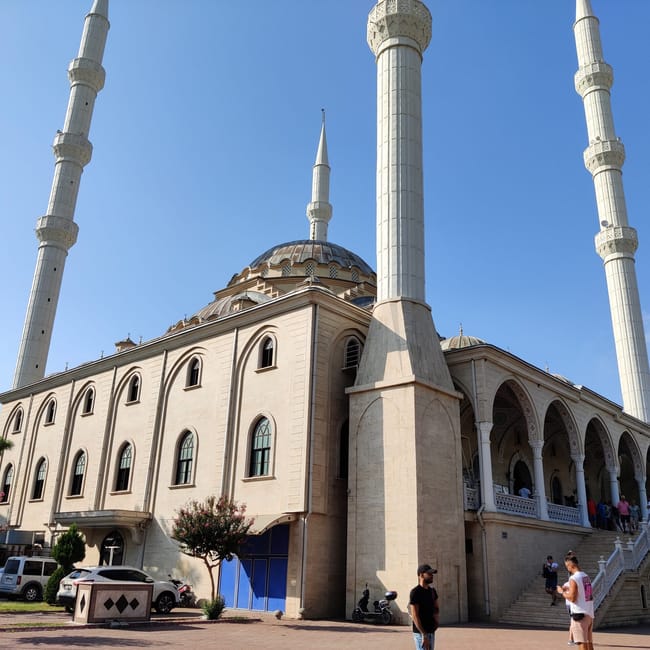 Meczet cami manavgat na tureckiej riwierze, z wysokimi minaretami i kopułami pod błękitnym niebem