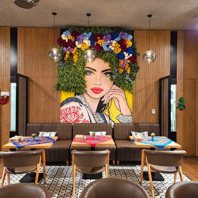 Wnętrze polka restaurant w doha z kolorowym muralem kobiety w kwiatowej koronie.