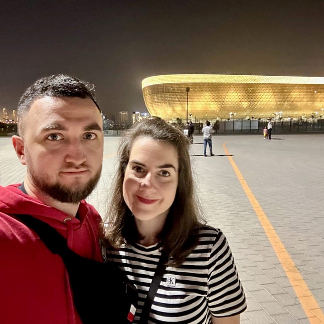 Para na tle stadionu lusail w dosze nocą.