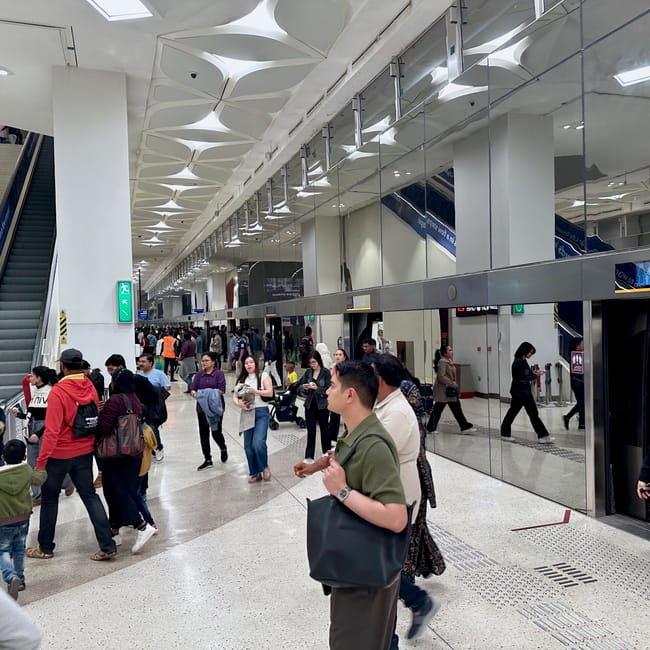 Peron doha metro w katarze z tłumem pasażerów i schodami ruchomymi