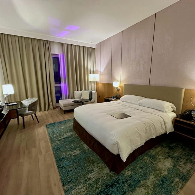 Pokój hotelowy w doha, katar z dużym łóżkiem i nastrojowym oświetleniem