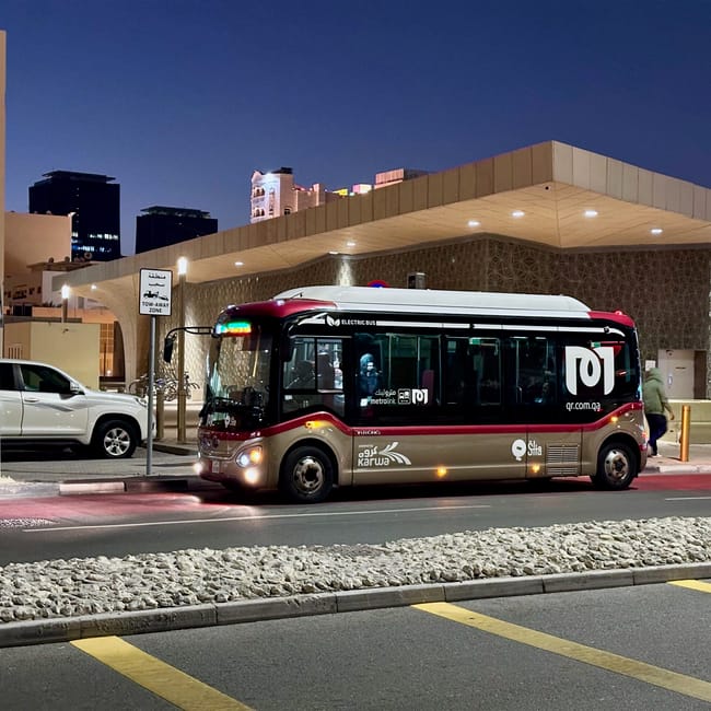 Elektryczny autobus publiczny w doha nocą przy przystanku metrolink.