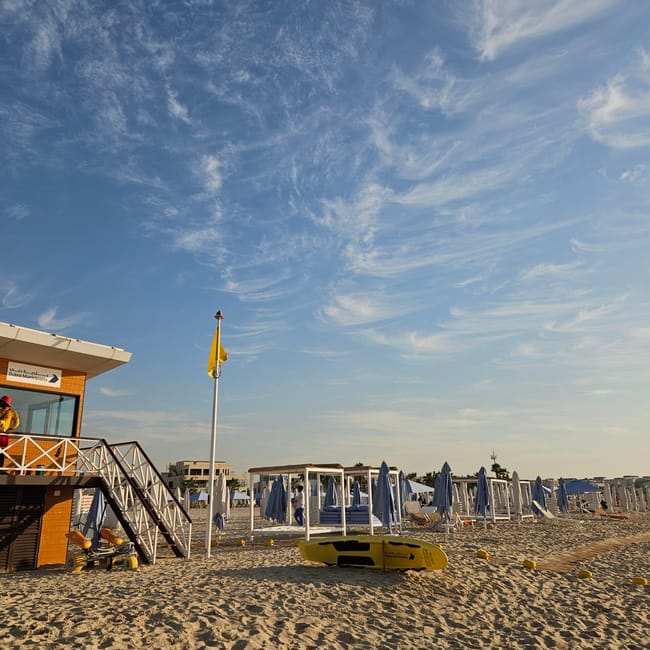 Plaża kite beach w dubaju z wieżą ratownika, parasolami i piaszczystym brzegiem bawah?