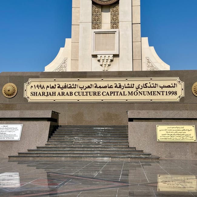 Sharjah arab cultural capital monument w zea z tablicą i schodami pod błękitnym niebem