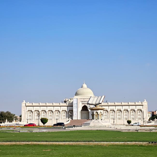Sharjah cultural square w uae z białym pawilonem i monumentalnym otwartym koranem na placu