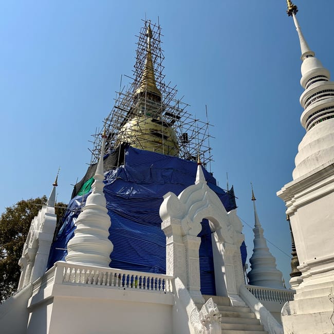 Wat suan dok w chiang mai z białą stupą i złotą wieżą w remoncie
