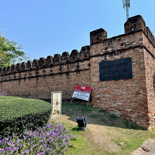 Brama suan dok gate w chiang mai z ceglanym murem i znakiem zakazu chodzenia po zabytkowej ścianie