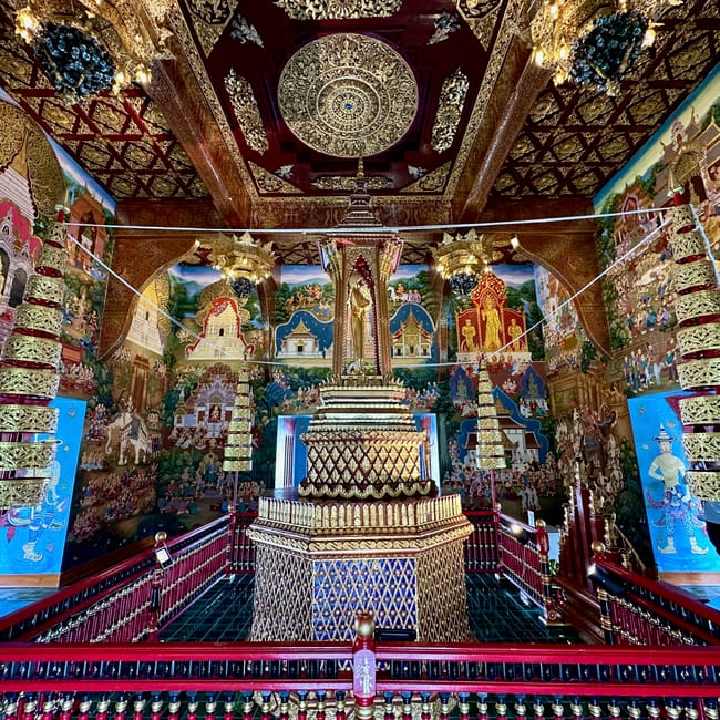 Wnętrze wat chedi luang w chiang mai z bogato zdobionym ołtarzem i kolorowymi malowidłami ściennymi