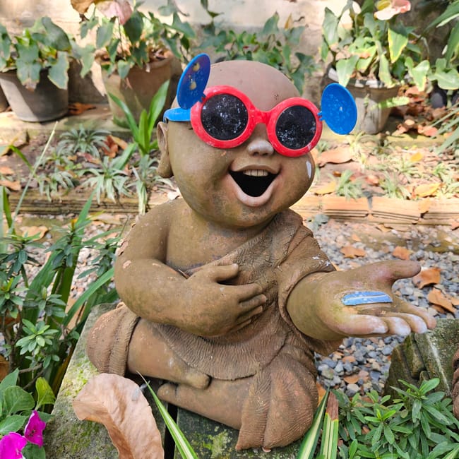 Rzeźba uśmiechniętego dziecka w okularach w ogrodzie wat tha mai w chiang mai, tajlandia