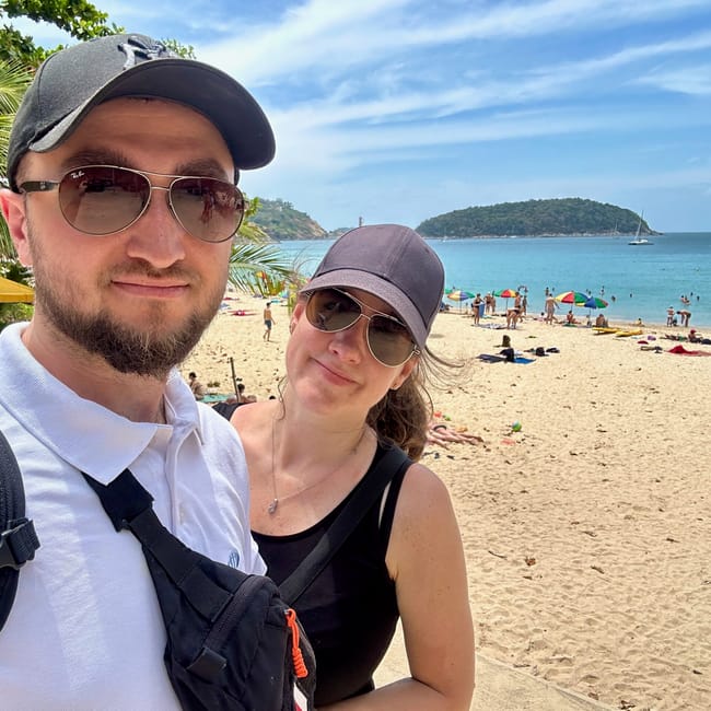 Selfie pary na plaży nai harn beach w phuket, z morzem i łodziami w tle